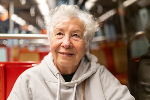 Happy elderly woman commuting by train or bus, enjoying her journey