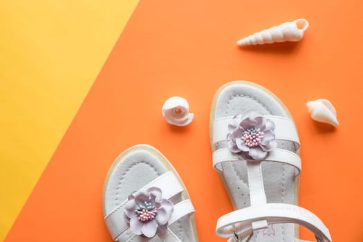 Pair of cute baby sandals on color background, top view