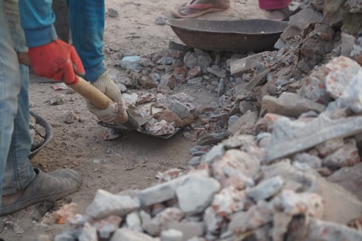 Workers are using tools to remove rubble at a construction site.
