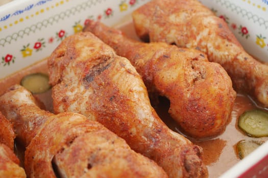 Juicy roasted chicken drumsticks garnished with flavorful spices and pickles.