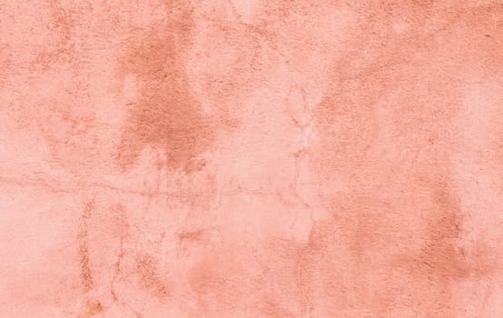 Plastered, weathered and painted pinkish, reddish peach colored concrete wall.