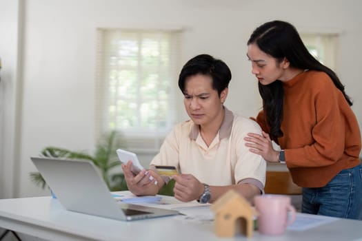 A young couple engages in financial discussions, reviewing their budget and offering support to each other in a home setting.