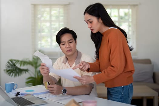 A couple engages in financial discussions, reviewing documents and sharing ideas to manage their budget effectively.