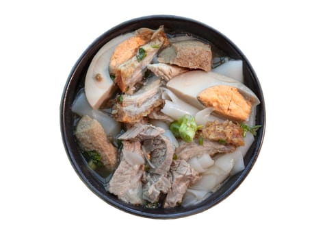 Rolled rice noodles in five-spices broth ingredients are boiled eggs, crispy pork, pork and tofu in brown stewed soup served on ceramic bowl. Chinese roll noodle soup Thai language called “Kuay Jab or Guay Jub” isolated on white background with clipping path. Selective focus.