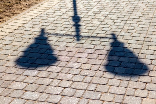 Shadow of the lamp post cast on the pavement