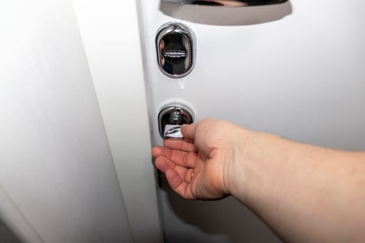 Man opening the door with metal handle and locks.