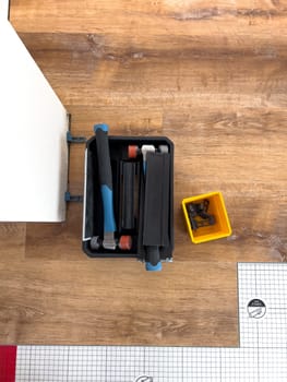 Broomfield, Colorado, USA-February 22, 2025-A close-up view of flooring installation tools placed on a partially completed wood laminate floor. The image shows a toolset, spacers, and an underlayment sheet, highlighting the ongoing home renovation process. The setup demonstrates the careful preparation and materials used for a smooth flooring installation.