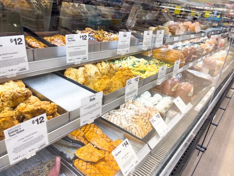 Castle Rock, Colorado, USA-February 22, 2025-A well-stocked Whole Foods deli case displaying a variety of fresh, prepared foods. The selection includes side dishes such as roasted vegetables, pasta salads, coleslaw, and other gourmet deli offerings. Each tray is labeled with pricing and descriptions, providing convenient meal options for customers.