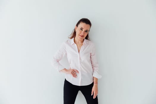 Portrait of a woman of 40 years old in a business suit near a white wall