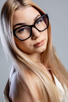 A stunning closeup portrait of a beautiful young woman with stylish glasses and skin that positively glows