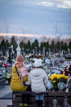 Children sit in a peaceful cemetery, reflecting on cherished memories among flowers and gravestones