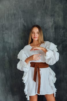 Portrait of a beautiful fashionable slender blonde woman in light summer clothes
