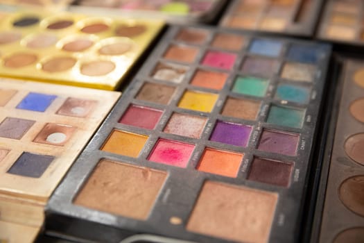 A vibrant array of colorful makeup palettes showcases a variety of trendy eyeshadow shades and textures