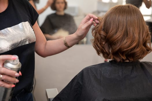A skilled stylist enhances a clients hairstyle with precision and care in a chic salon environment
