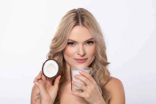 A stunning woman showcases her skincare routine with a cream and a candle, emphasizing beauty and self-care.