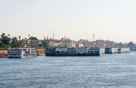 Luxor, Egypt - 2 November 2024: Many Nile River cruise ships are docked alongside each other along the shore of the Nile River