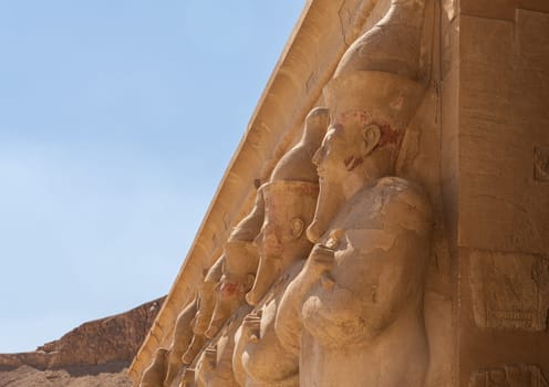 Side view of large statues of pharoahs at Hatshepsut Temple near Luxor Egypt by the columns of the Mortuary