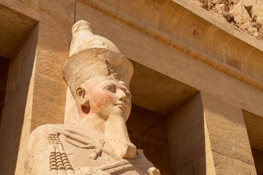 Large statue of head of pharoah at Hatshepsut Temple near Luxor Egypt by the columns of the Mortuary