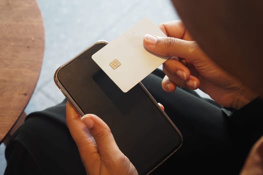 A person uses a card to make a mobile payment on their device.