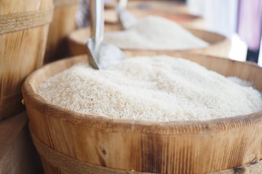 Baskets filled with white rice are arranged at a market stall for sale.