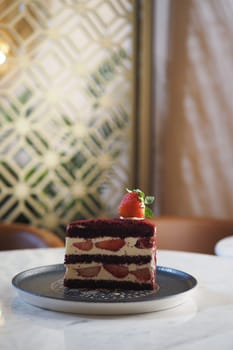 A vibrant red velvet cake topped with fresh strawberries sits elegantly.