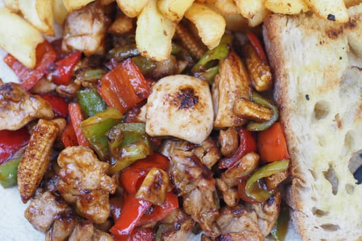 Juicy grilled chicken with colorful veggies and crispy fries.