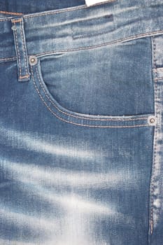 Close-up view of denim jeans featuring a trendy fade and pockets.