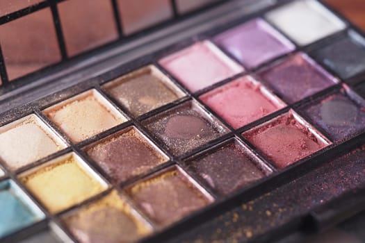 Close view of a makeup palette with diverse eyeshadow colors and finishes.