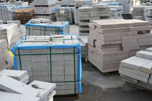 Paving stones arranged in neat stacks at a busy construction area.