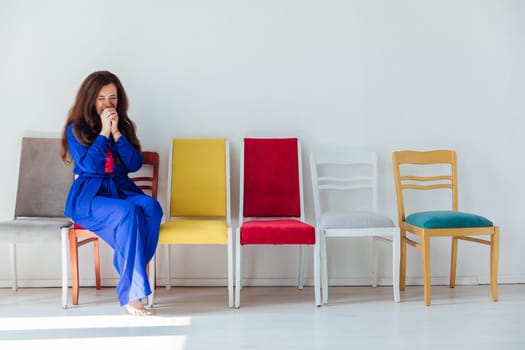 Woman in blue sitting on chairs in room interior
