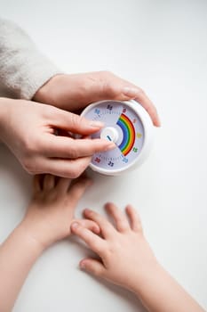 Adult and child adjusting colorful timer together.