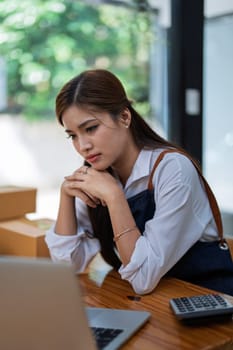 Young woman engaged in online business with stress thoughtful within data products Sales did not meet target Selling products of This month.