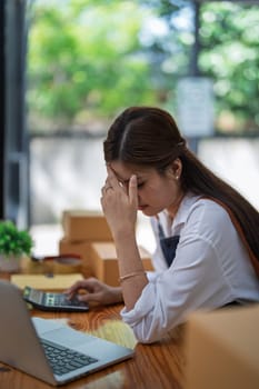 Young woman engaged in online business with stress thoughtful within data products Sales did not meet target Selling products of This month.