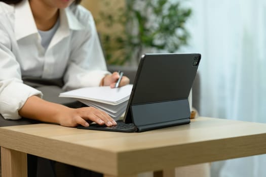 Close up shot unrecognizable woman typing on a digital tablet keyboard.