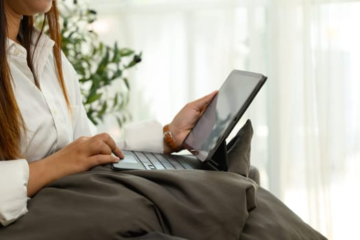 Close up shot unrecognizable woman typing on a digital tablet keyboard.