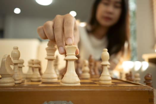 Hand moving the king piece on a wooden chessboard. Critical thinking, decision making and strategic planning concept.