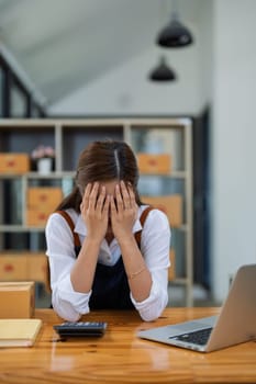 Young woman engaged in online business with stress thoughtful within data products Sales did not meet target Selling products of This month.