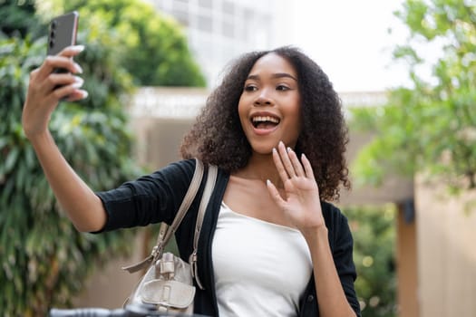 A joyful young woman poses for a selfie in a vibrant outdoor setting, showcasing excitement and connection with nature.
