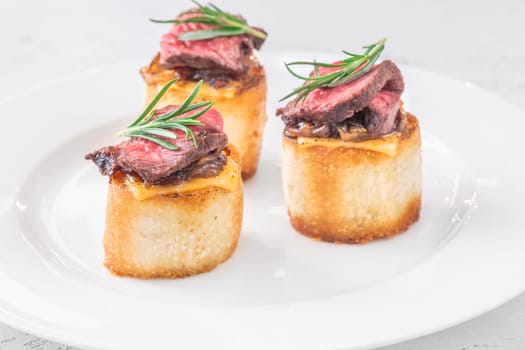 Crispy baguette filled with melted cheese, tender steak, sweet onions, and fresh rosemary