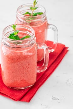 Creamy tropical smoothie with cherry, banana, and pineapple in mason jars