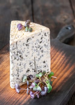 Creamy, veined Roquefort cheese with bold flavor, elegantly placed on a wooden board