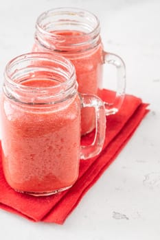 Creamy tropical smoothie with cherry, banana, and pineapple in mason jars