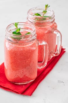 Creamy tropical smoothie with cherry, banana, and pineapple in mason jars