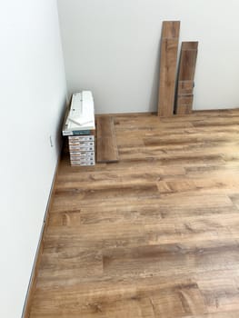 Broomfield, Colorado, USA-February 16, 2025-A room with newly installed wood-look flooring, with extra planks stacked against the wall. The flooring adds warmth and a modern touch to the space. The ongoing installation process suggests a home renovation or remodeling project.