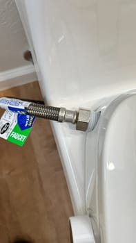 Broomfield, Colorado, USA-January 26, 2025-Close-up view of a newly installed water supply line connected to a toilet. The braided stainless steel hose is securely fastened, ensuring proper water flow. The installation is part of a home improvement or bathroom renovation project.