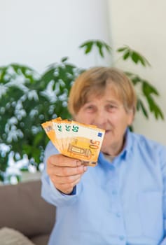 Old woman with money. Selective focus. People,
