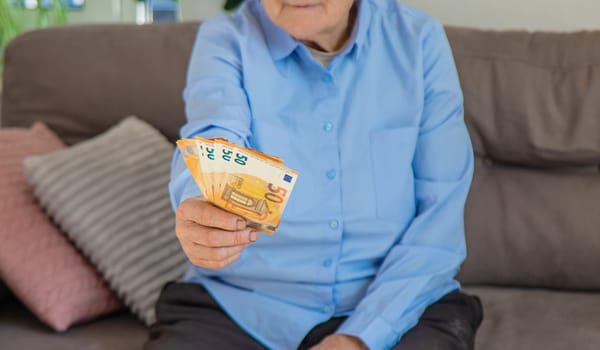 Old woman with money. Selective focus. People,