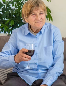 Old woman drinking wine. Selective focus. People,
