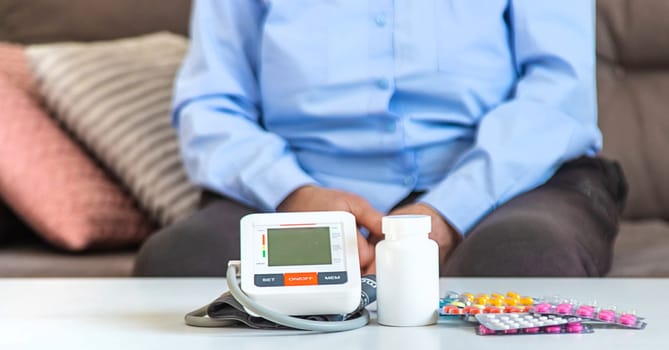 An old woman measures her blood pressure. Selective focus. people,