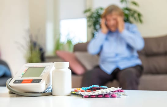 An old woman measures her blood pressure. Selective focus. people,